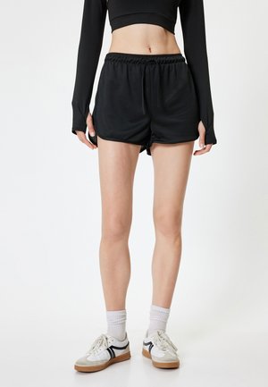 Zwarte sportieve shorts met een elastische tailleband en trekkoord. Bevat een gladde textuur en zijsplitten voor gemakkelijke beweging.