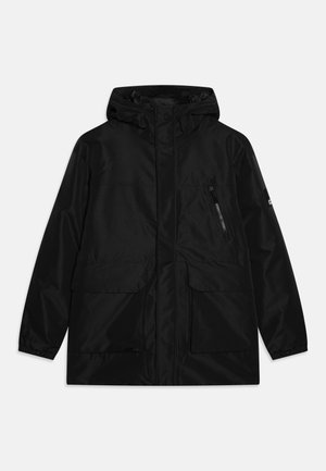 Giacca nera impermeabile con cappuccio, chiusura frontale con zip, due grandi tasche anteriori e una tasca laterale con zip. Finitura liscia e opaca.