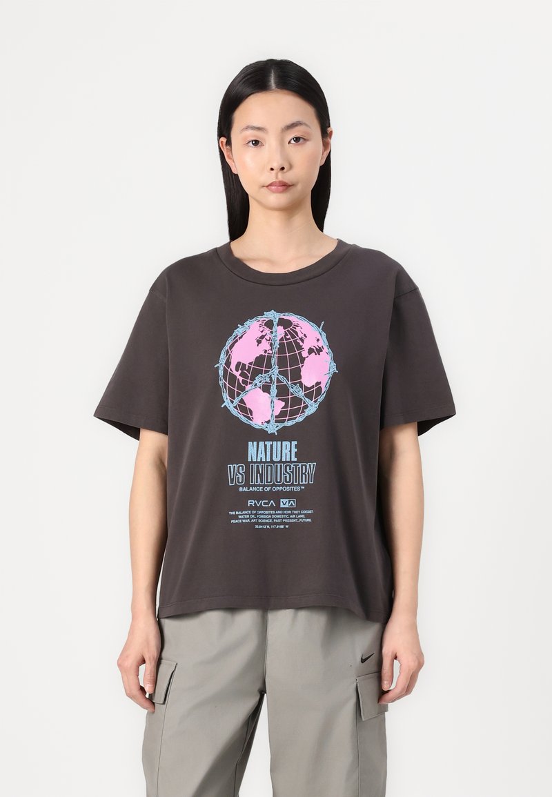 Afslappet brun t-shirt med et globe-grafik i pink og blå, tekst med teksten "NATURE VS INDUSTRY," kortærmet og med rund hals.
