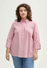 Camicia a righe rossa e bianca, con colletto a punta, maniche a tre quarti e vestibilità comoda. Tessuto dalla superficie liscia.