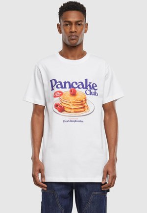White cotton t-shirt featuring a graphic of stacked pancakes with syrup and raspberries, labeled "Pancake Club" in purple text.