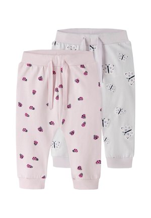 Dwie pary spodni dla maluchów, jedne jasno różowe z różowymi wzorami biedronek, drugie białe z czarno-białymi wzorami motyli, obie z talią na sznurek.