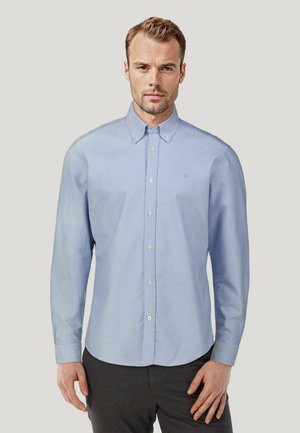 Light blue long-sleeve button-up shirt made of cotton blend, featuring a collar, front pocket, and white buttons. Plain texture, no patterns.