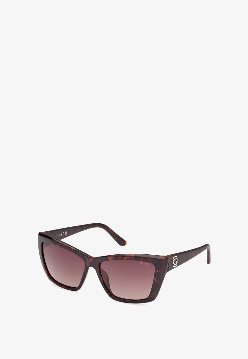 Skořicové sluneční brýle s gradientními hnědými skly. Geometrický rám s výraznými stranicemi s akcentem stříbrného loga. Hladký povrch.