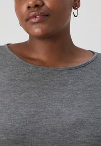 Gray knit top with a round neckline, smooth texture, and short sleeves. Features subtle stitching along the neckline and upper chest.
