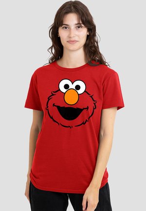 Red cotton t-shirt featuring a large, cartoon-style graphic of a character's face with big eyes and an orange nose on the front.