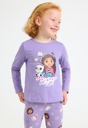 La maglietta a maniche lunghe viola presenta una grafica di un cartone animato con una ragazza e animali, con accenti floreali. I leggings coordinati mostrano un motivo di personaggi e fiori.