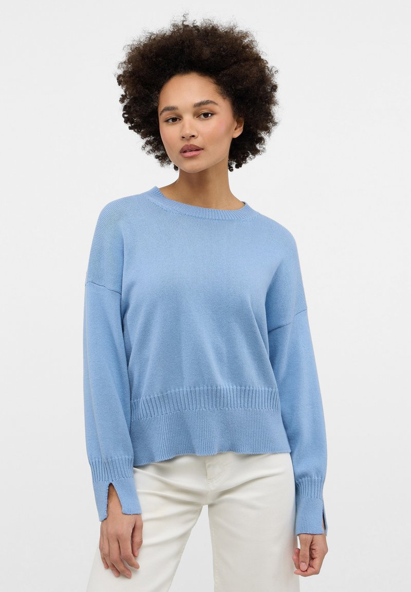 Maglione lavorato a maglia azzurro chiaro con scollo rotondo, spalle cadenti e orlo a coste. Presenta delle fessure laterali ai polsini per un tocco di dettaglio.