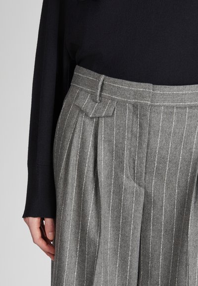 Pantaloni a righe grigie realizzati in tessuto testa, con un design plissettato, tasche laterali e una vita con passanti per la cintura.