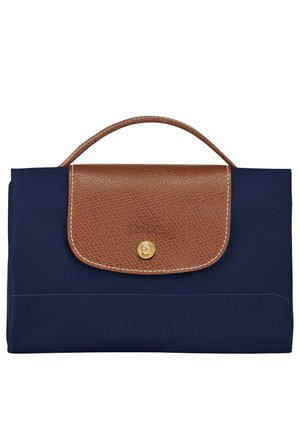 Prostokątna torebka w kolorze granatowym z brązową fakturowaną skórzaną klapką i uchwytem, zabezpieczona złotym zatrzaskiem na guzik.