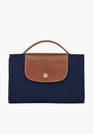 Prostokątna torebka w kolorze granatowym z brązową fakturowaną skórzaną klapką i uchwytem, zabezpieczona złotym zatrzaskiem na guzik.