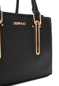 Bolso de mano sintético negro con herrajes dorados, dos asas en la parte superior y un acabado texturizado. Incluye un logo de la marca y acentos metálicos.