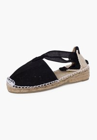 Espadrilles in tessuto nero con suola in juta intrecciata, dotate di punta chiusa e fasce incrociate. Cuciture bianche che accentuano il bordo.