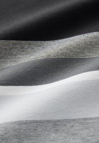 Tessuto dalla texture morbida con strisce orizzontali in diverse tonalità di grigio e bianco, che creano un aspetto stratificato e ondulato.