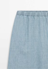Gonna in chambray blu chiaro con cintura elastica, che mostra la parte superiore anteriore su sfondo bianco.
