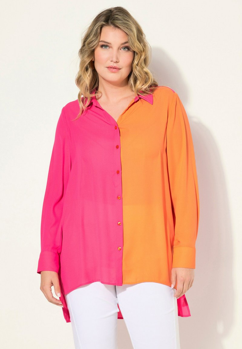 Camisa de botón mitad rosa y mitad naranja, de mangas largas, fabricada en tejido ligero, con botones dorados y un dobladillo curvado. Pantalones blancos.