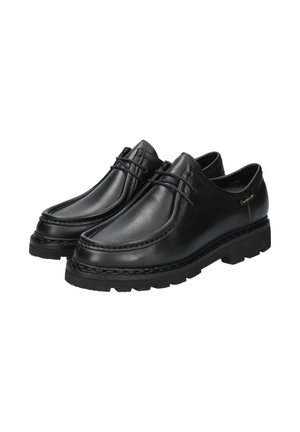 Chaussures en cuir noir avec un bout arrondi, un laçage décoratif, une semelle épaisse avec adhérence et des accents de couture subtils le long des bords.