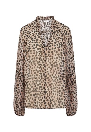 Blouse beige à manches longues avec taches noires irrégulières, col à volants, nœud à l'avant et poignets élastiques.