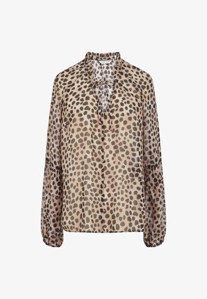 Blouse beige à manches longues avec taches noires irrégulières, col à volants, nœud à l'avant et poignets élastiques.