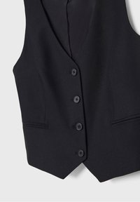 Schwarze Stoffweste mit tailliertem Schnitt, V-Ausschnitt, fünf schwarzen Knöpfen und zwei Fronttaschen. Strukturierter Stoff verleiht dezente Tiefe.