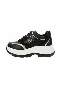 Sneaker nera con tomaia nera testurizzata, dettagli dorati e una spessa suola piatta bianca. Presenta lacci neri e un logo laterale con marchio.