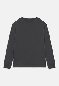 Μακρυμάνικο πουκάμισο σε σκούρο γκρι, κατασκευασμένο από απαλό βαμβάκι. Διαθέτει στρογγυλή λαιμόκοψη και ριμπ μανσέτες με απλή, υφασμάτινη υφή.