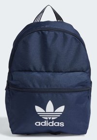Mörkblå ryggsäck tillverkad av hållbart material, med en framficka med dragkedja och en stor vit Adidas-logotyp. Styva handtag med vertikala ränder för bärande.