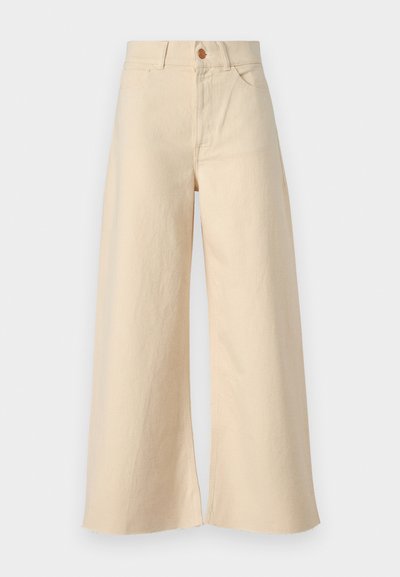 Bež traperice širokih nogavica, s visokim strukom, prednjim džepovima, zatvaranjem na gumb i istrošenim rubovima.