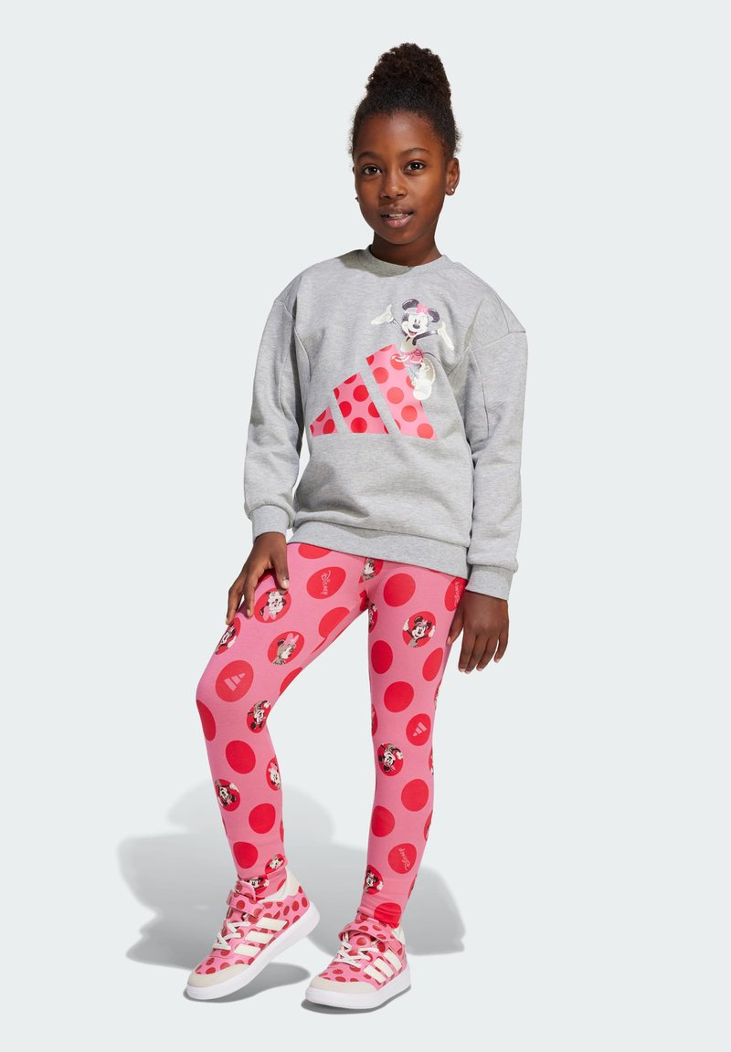 Gray sweatshirt featuring a graphic character and red polka dots, paired with pink leggings with circular patterns and character prints.