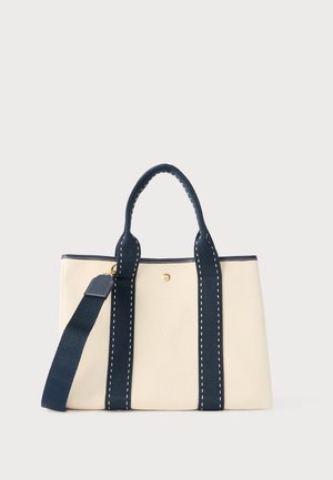 Borsa a mano rettangolare beige con manici blu navy, cinturini verticali e tracolla regolabile su sfondo semplice.