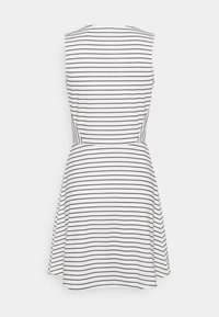 Robe blanche sans manches avec fines rayures horizontales noires, taille cintrée et jupe évasée, vue de dos sur un fond uni.