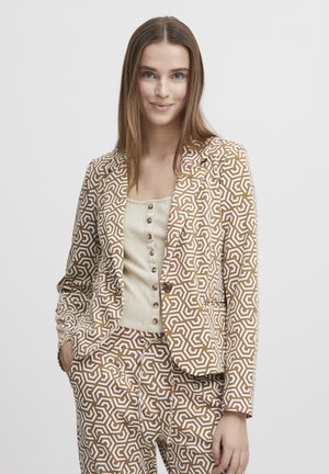 Brown and white patterned blazer with geometric design, paired with a cream ribbed tank top featuring buttons. Smooth fabric, tailored fit.
