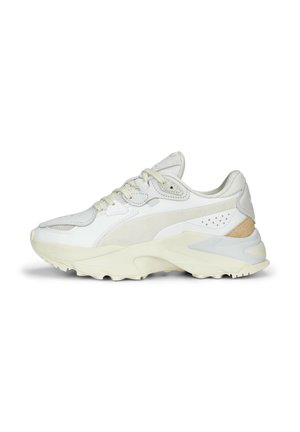 Białe sneakersy z połączeniem gładkich i teksturowanych materiałów. Okrągły czubek, sznurowany fason, z subtelnymi beżowymi akcentami na pięcie.