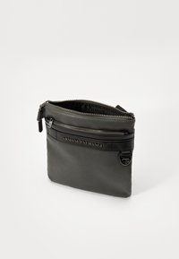 Pochette in pelle grigia con una cerniera superiore e una tasca frontale, caratterizzata dal logo impresso "Armani Exchange" e una finitura liscia.