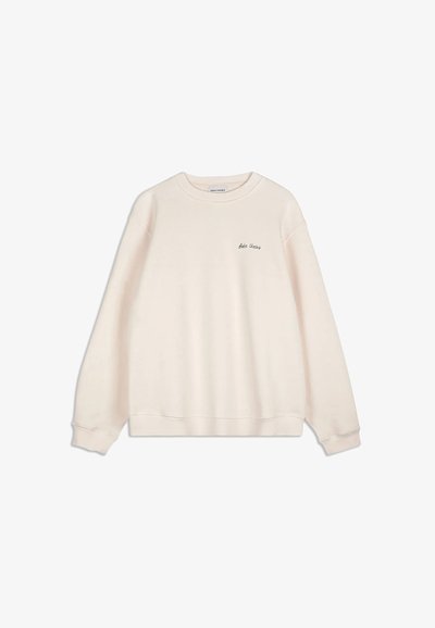 Felpa a maniche lunghe color crema con polsini e orlo a coste, che presenta un piccolo testo "Bobo Choses" nella zona sinistra del petto.