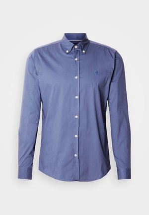 Button-up shirt in light blue fabric, featuring a pointed collar, long sleeves, and a small embroidered logo on the left side of the chest.