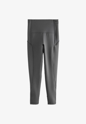 Leggings grigi elastici con vita media, dotati di tasche laterali e cuciture senza giunture, progettati per comfort e flessibilità.