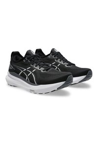 Zwarte sportieve schoenen met een bovenwerk van mesh, witte accentlijnen, een gevoerde zool en een getextureerde rubberen buitenzool voor grip.
