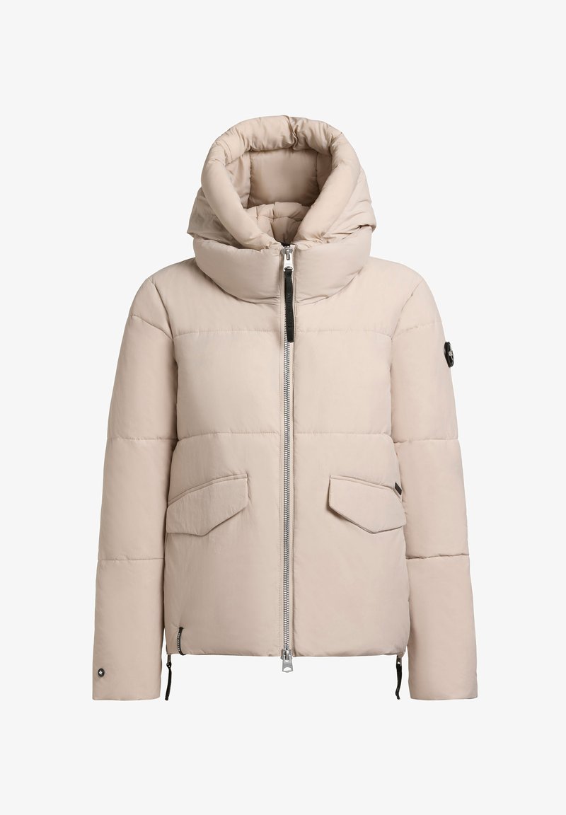 Beige pūkains mētelis ar augstu kapuci, priekšējo ievo un divām kabatām. Gluda tekstūra ar quiltētiem šuvēm un melnu ieveri.