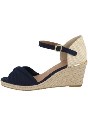 Granatowe sandały na koturnie z oplecionym materiałem, plecionym obcasem ze sznurka jutowego oraz kontrastowym, fakturowanym tyłem. Pasek wokół kostki z złotą klamrą.