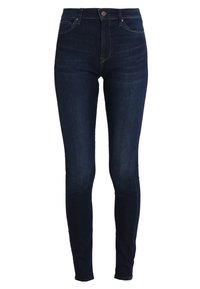 Jeans ajustados de color azul oscuro fabricados en denim, que cuentan con cinco bolsillos, trabillas para cinturón y un cierre de botón en la parte frontal. Textura suave con un desgastado mínimo.