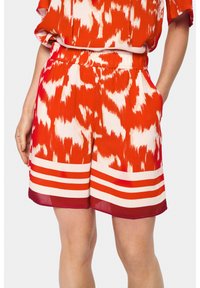 Rdeče in bele kratke hlače s vzorcem, z elastičnim pasom, stranskimi žepi in črtastimi poudarki pri robu. Lahka tkanina.