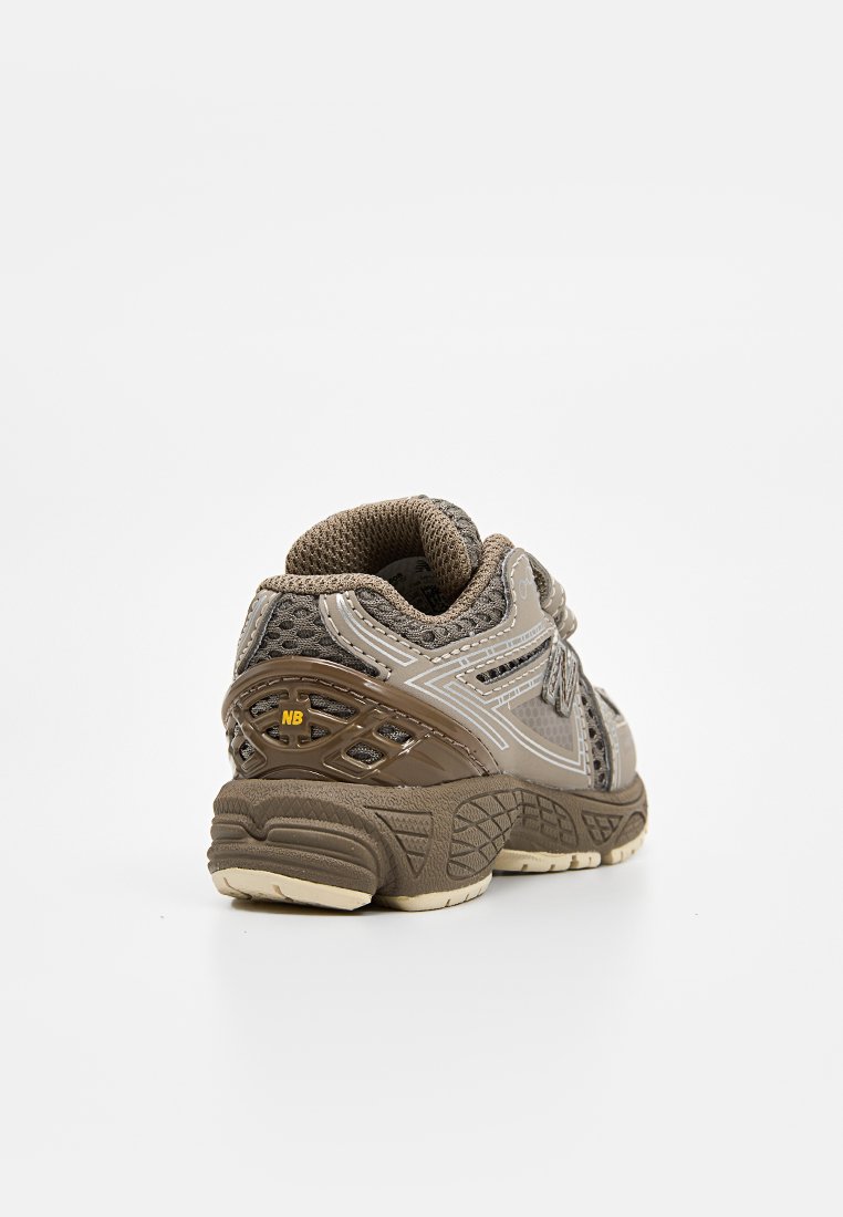 Chaussure de sport grise et brune avec un matériau en maille et synthétique, semelle texturée, col rembourré et accents réfléchissants sur les côtés.