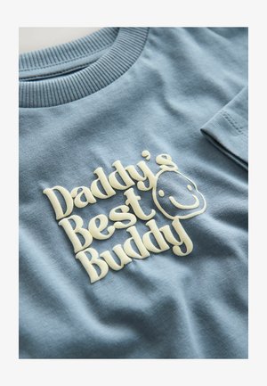 Lyseblå bomulds-sweatshirt med teksturerede cremefarvede bogstaver, der siger "Daddy's Best Buddy," med en smilende ansigtsdetalje.