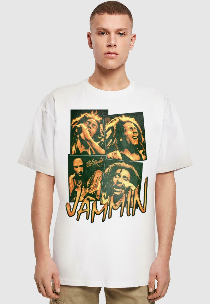 Hvit oversized T-skjorte med grafisk trykk av fire bilder, inkludert musikere og ordet "JAMMIN" i fet oransje tekst.