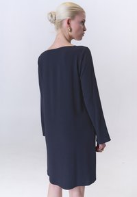 Navyblaues langärmeliges Kleid mit entspannter Silhouette, einem quadratischen Ausschnitt und einer glatten Textur, das knapp über dem Knie endet.