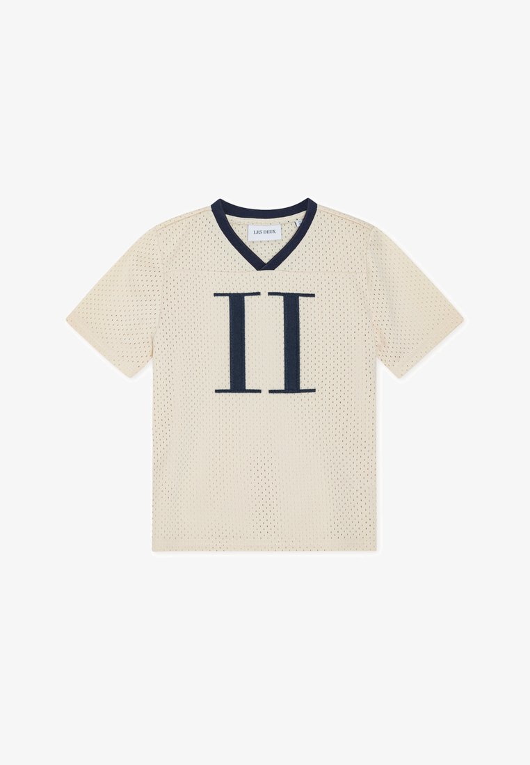 Τζέρσεϊ με κοντό μανίκι από δίχτυ σε μπεζ χρώμα με ναυτικά μπλε στοιχεία. Διαθέτει V-λαιμόκοψη και μεγάλο «II» τυπωμένο σε ναυτικό μπλε στο μπροστινό μέρος, προσφέροντας ένα σπορτίφ σχεδιασμό.