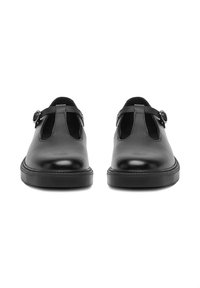 Zapatos estilo Mary Jane de cuero negro con una correa de hebilla y suelas gruesas de goma, mostrados uno al lado del otro desde el frente.