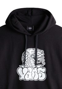 Sweat à capuche noir Vans avec un graphisme blanc représentant une tête de serpent féroce au-dessus du logo Vans en lettres épaisses et arrondies sur la poitrine.