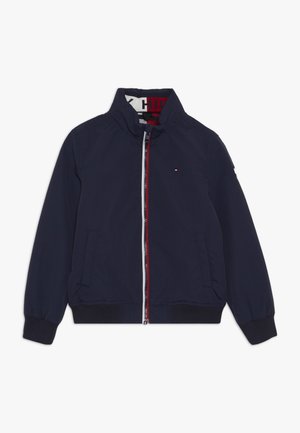 Veste zippée bleu marine avec poignets et ourlet côtelés, col montant, poches latérales et petit logo Tommy Hilfiger rouge, blanc et bleu sur la poitrine.